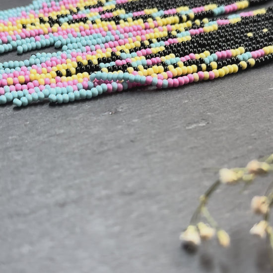 Unique handmade beaded earrings in black, blue, yellow and pink with geometric design. Boho style statement jewelry, cute multicolor earrings for women video 1