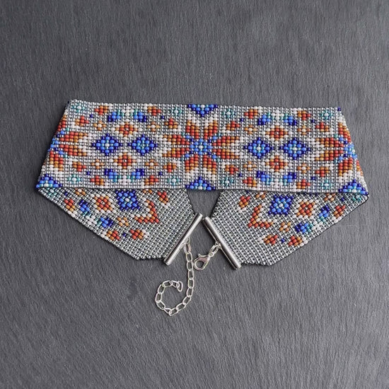 Unique handmade beaded choker with brown star ornament and blue accents on transparent base. Unique boho statement choker necklace for standout style video 1
