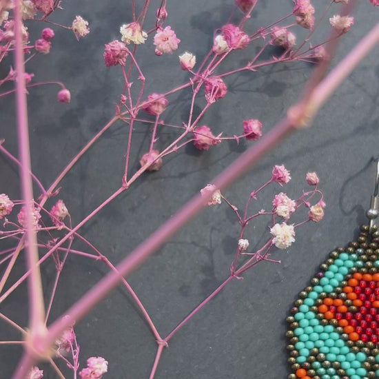 Unique handmade long beaded earrings in turquoise, orange, and red with floral design and fringe. Boho statement jewelry, cute multicolor earrings for women video 1