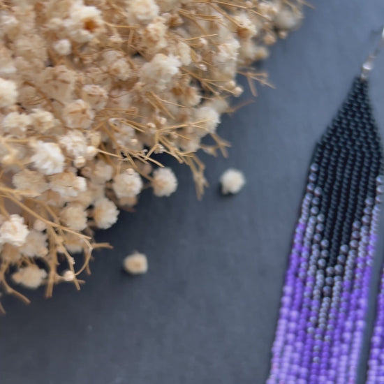 Long black beaded earrings in purple ombré style with fringe and silver tips. Handmade boho jewelry that is unique, vibrant, and adds elegance and movement  video 1