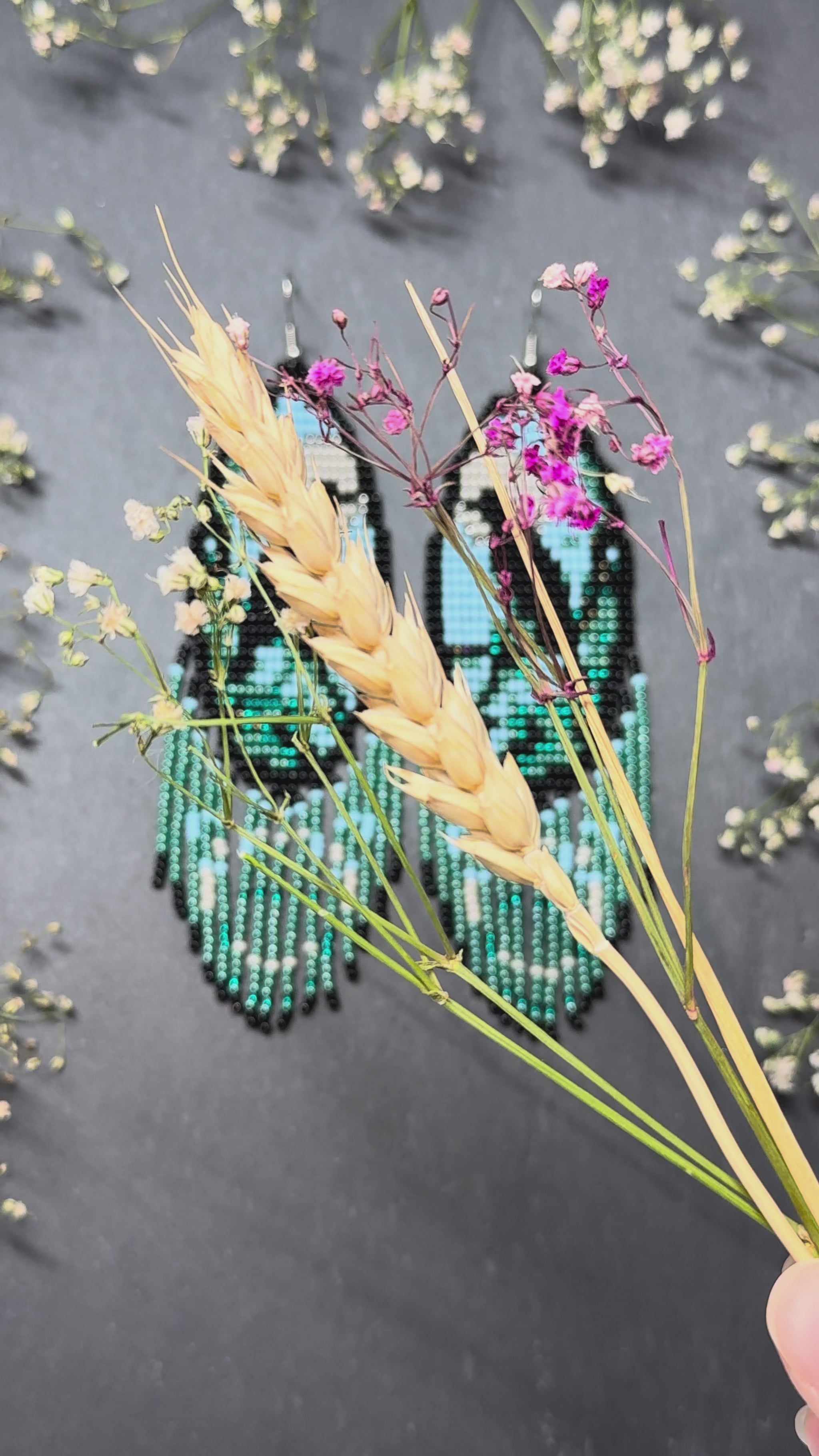 Long handmade beaded earrings in black, green, blue and beige featuring a raven and moon design with fringe. Boho statement jewelry, unique gift for her video 1