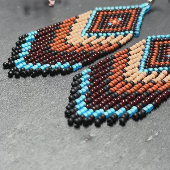 Handmade blue and brown beaded fringe earrings with geometric style. Unique bright boho statement jewelry with Native-inspired design and artisan beadwork video 1