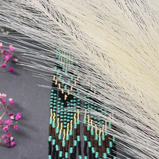 Handmade long black, turquoise, and gold beaded earrings with Native American ethnic design and fringe. Unique boho statement earrings for women video 1