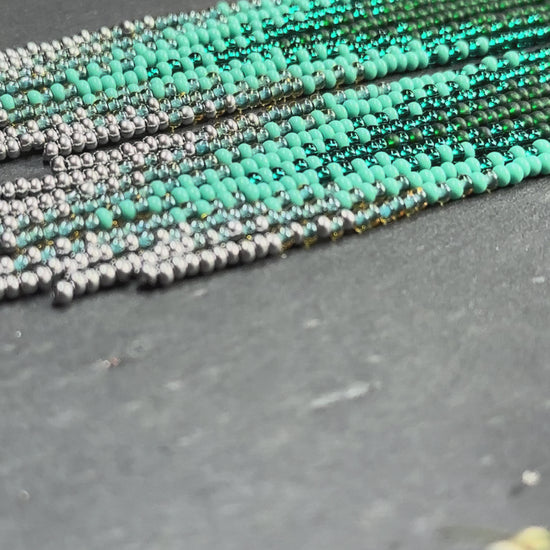 Long green and silver beaded fringe earrings on hoop base with 925 sterling silver hooks. Bright handmade statement earrings with gradient design in boho style video 1
