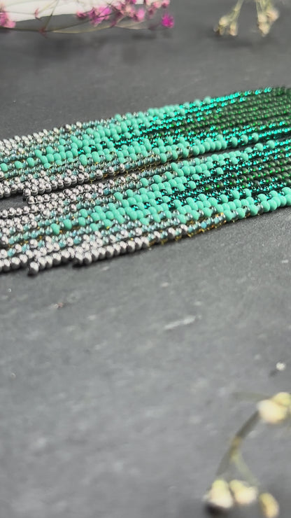 Long green and silver beaded fringe earrings on hoop base with 925 sterling silver hooks. Bright handmade statement earrings with gradient design in boho style video 1